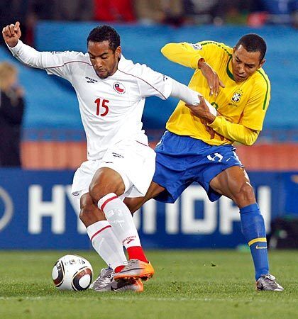 Chile midfielder Jean Beausejour, left, battles for the ball with Brazil midfielder Gilberto Silva.