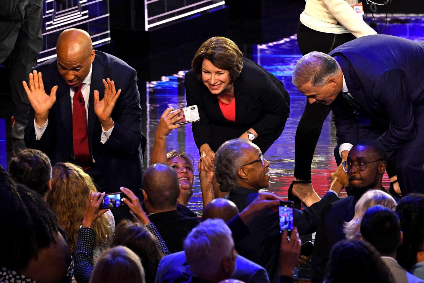 Democratic presidential hopefuls (fromL) US Senator from New Jersey Cory Booker and US Senator from Minnesota Amy Klobuchar greet supporters as Governor of Washington Jay Inslee greets US activist Al Sharpton after participating in the first Democratic primary debate of the 2020 presidential campaign season hosted by NBC News at the Adrienne Arsht Center for the Performing Arts in Miami, Florida, June 26, 2019.