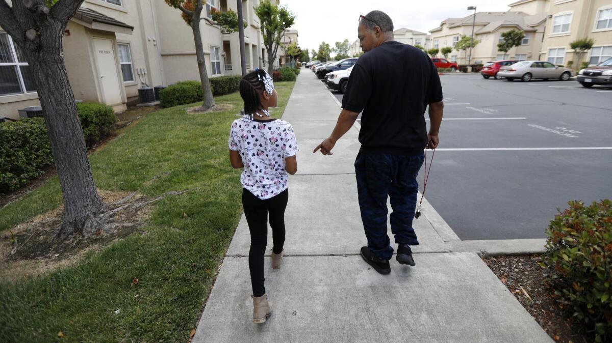 Maurice Caldwell walks with his daughter Amaya Haynes, 9, in Sacramento.