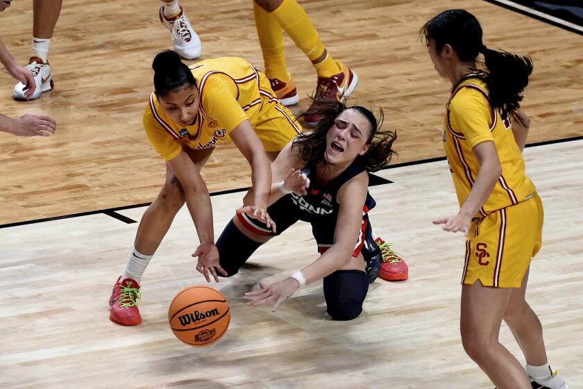 Southern California guard JuJu Watkins, left, goes after a loose ball with UConn guard Nika Muhl, right, during the second half of an Elite Eight college basketball game in the women's NCAA Tournament, Monday, April 1, 2024, in Portland, Ore. (AP Photo/Steve Dykes)