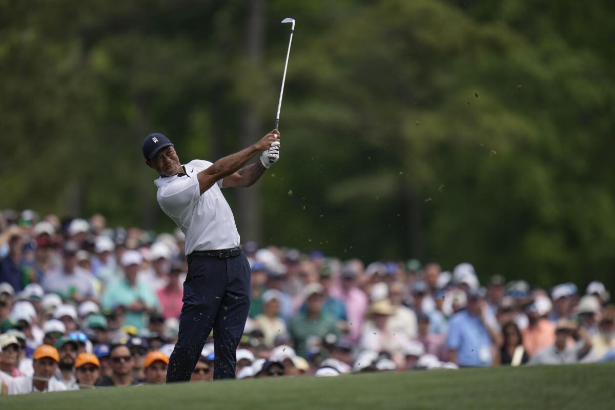 Tiger Woods watches his tee shot on the 12th hole during the first round of the Masters at Augusta National Golf Club.