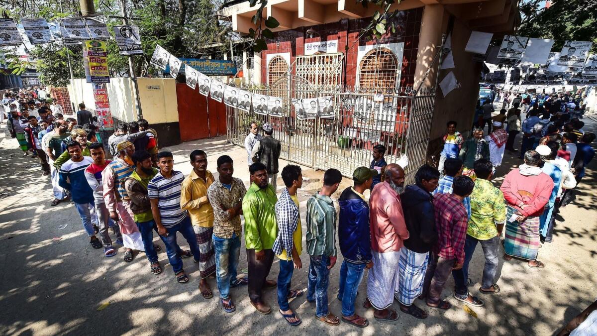Bangladeshi voters wait in line outside a polling station in Dhaka.
