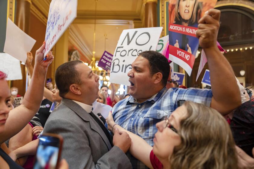 Pastor Michael Shover of Christ the Redeemer Church in Pella, left, argues with Ryan Maher, of Des Moines, as protestors clashed in the Iowa State Capitol rotunda, while the Iowa Legislature convenes for special session to pass 6-week 'fetal heartbeat' abortion ban, Tuesday, July 11, 2023. (Zach Boyden-Holmes/The Des Moines Register via AP)