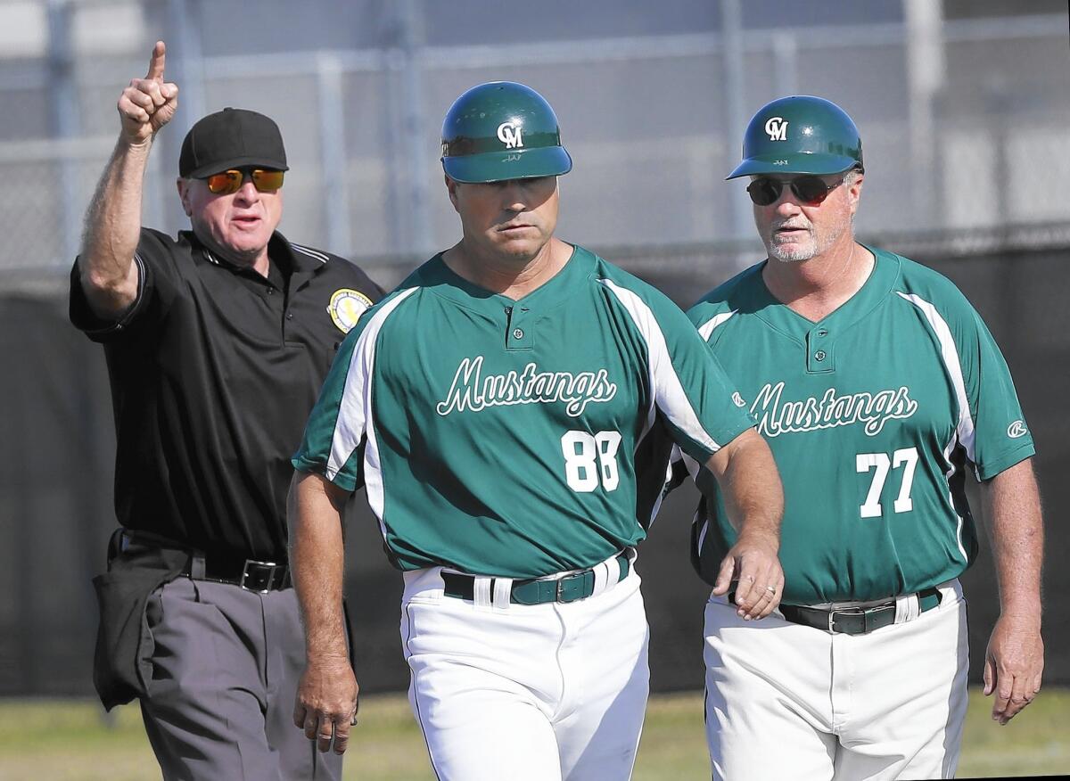 Costa Mesa High Coach Paul Grady (center) is ejected during the game against Estancia on Friday.