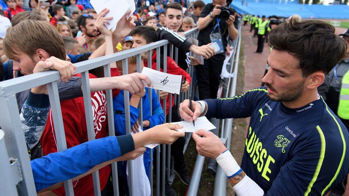 Switzerland's goalkeeper Roman Buerki signs autographs in Togliatti, Russia.