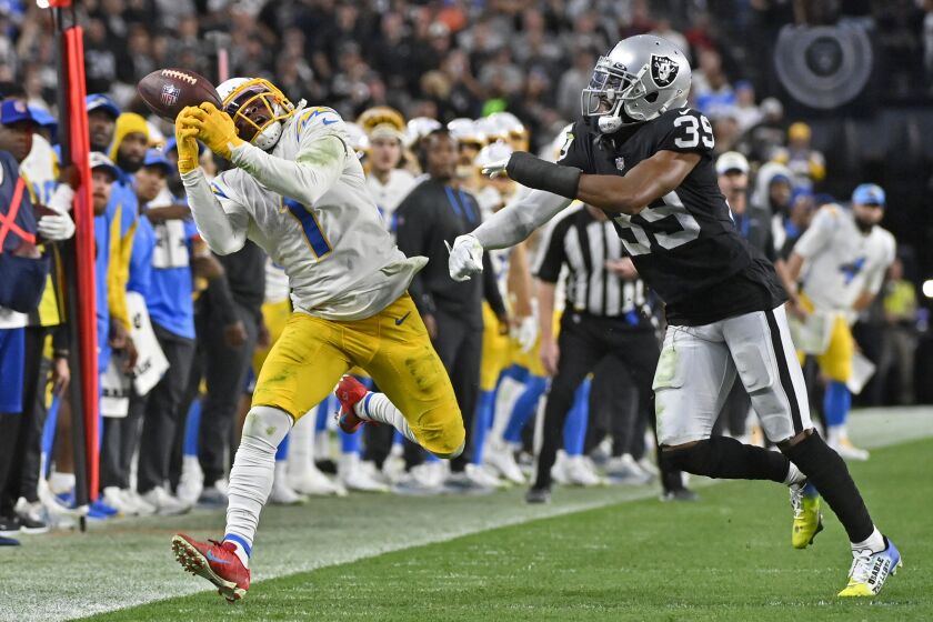Los Angeles Chargers wide receiver DeAndre Carter (1) misses a pass on fourth down to turn the ball over on downs, as Las Vegas Raiders cornerback Nate Hobbs (39) covers, during the second half of an NFL football game, Sunday, Dec. 4, 2022, in Las Vegas. The Raiders won 27-20. (AP Photo/David Becker)