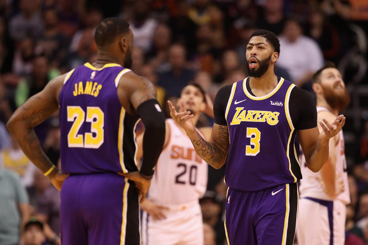 Lakers forward Anthony Davis, left, speaks with teammate LeBron James during a win over the Phoenix Suns earlier this month.