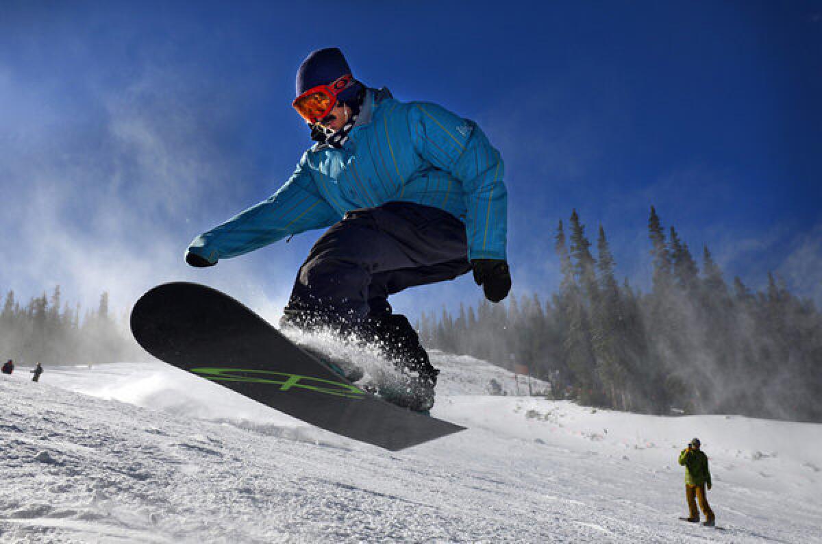 A snowboarder hits a jump at Arapahoe Basin Ski Resort in Colorado.