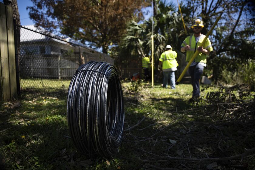 Workers for Florida Power and Electric repair a power line damaged by Hurricane Ian in Naples, Fla., on Monday, Oct. 3, 2022. The utility said Monday that it expects to have nearly all power restored to its customers with habitable homes by the end of the week. (AP Photo/Robert Bumsted)