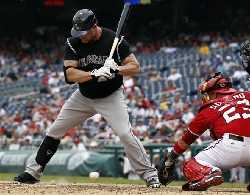 Washington Nationals catcher Jhonatan Solano, right, cannot handle a wild pitch from relief pitcher Tyler Clippard as Colorado Rockies batter Jason Giambi (23) stands by during the ninth inning of a baseball game on Sunday, July 8, 2012, in Washington. The Rockies won 4-3. (AP Photo/Alex Brandon)