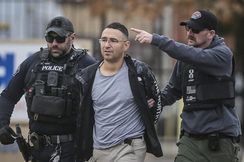 Solomon Pena, center, a Republican candidate for New Mexico House District 14, is taken into custody by Albuquerque Police officers, Monday, Jan. 16, 2023, in southwest Albuquerque, N.M. Pena was arrested in connection with a recent series of drive-by shootings targeting Democratic lawmakers in New Mexico. (Roberto E. Rosales/The Albuquerque Journal via AP)