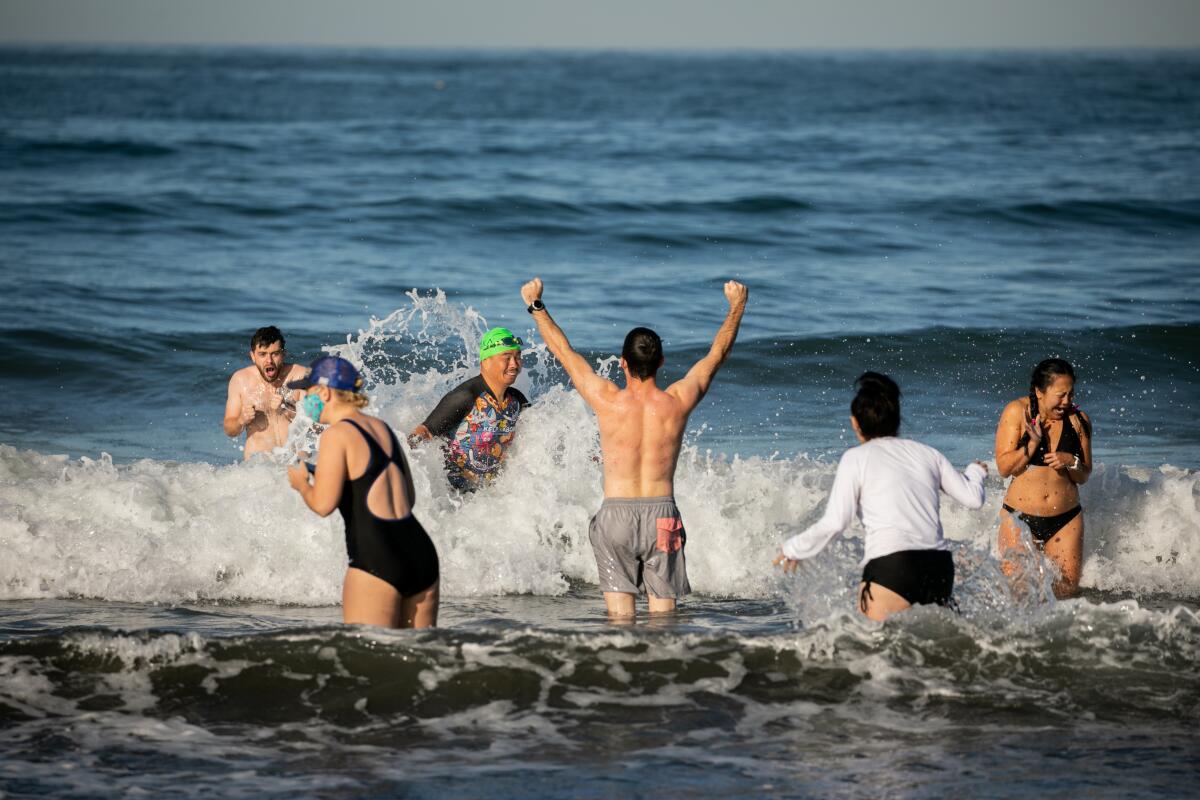 People take part in the unofficial 2021 Polar Bear Plunge on New Year's Day at La Jolla Shores.