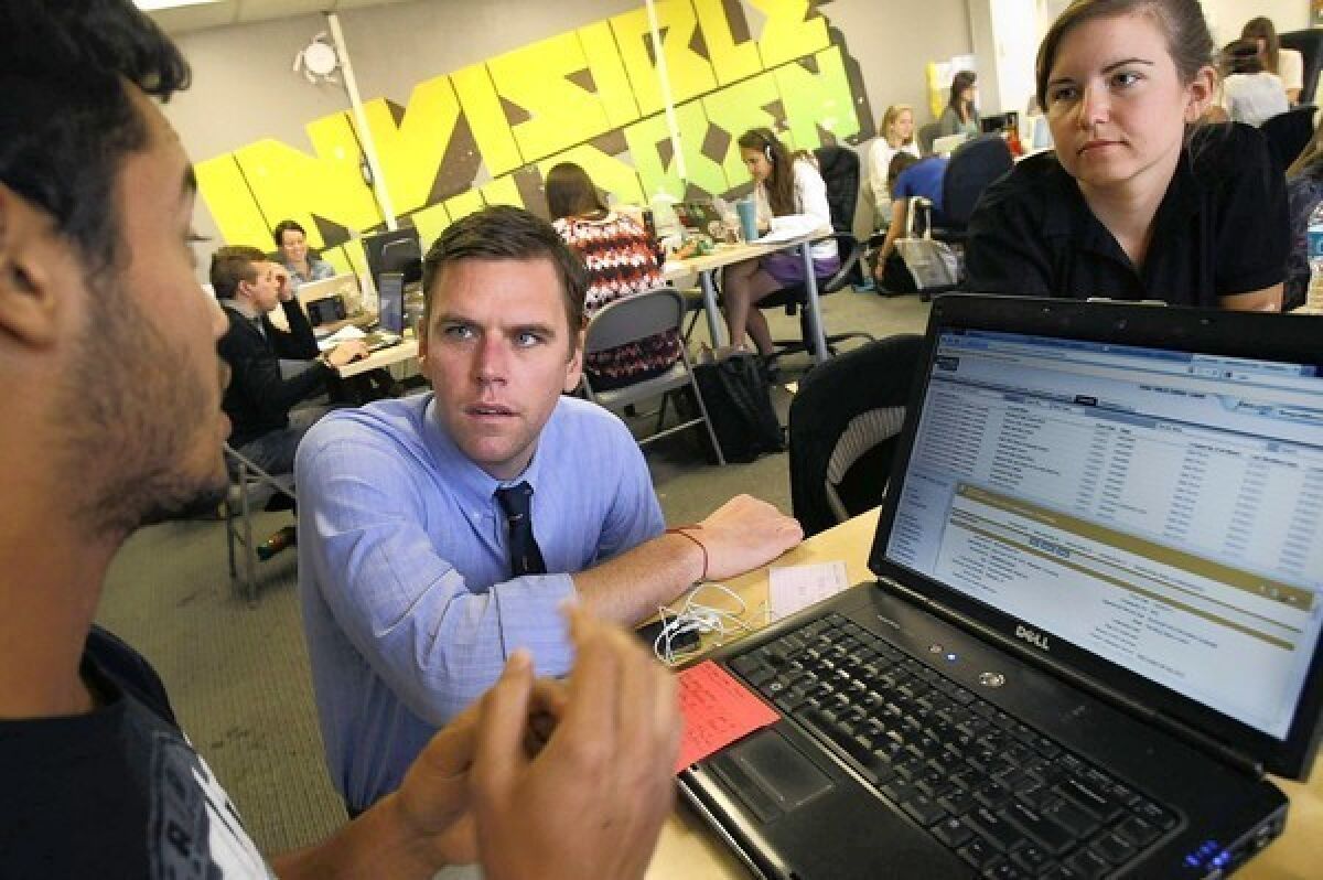 Invisible Children’s chief executive, Ben Keesey, talks with interns Nathaniel Pavon of Hemet and Heather Hochstedler of Nolesville, Ind., on June 28 in the group's San Diego headquarters.