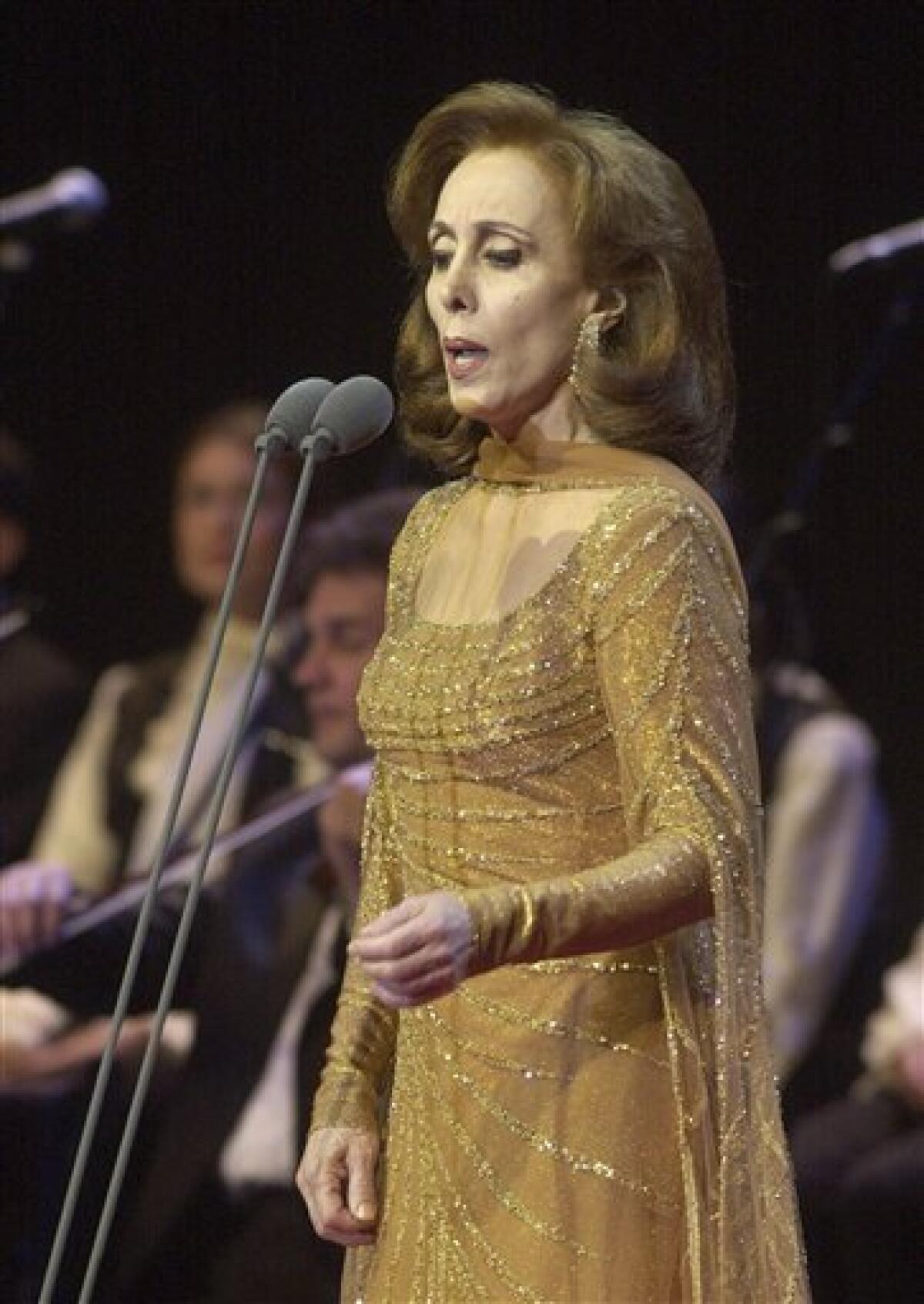 In this photo taken on Aug. 9, 2002, Lebanon's diva Fairouz performs during a concert in Beiteddine, in the central Chouf mountains southeast of Beirut, Lebanon. For four decades, Lebanese singer Fairouz has performed on the world's most prestigious stages, moving audiences to tears with songs of freedom, justice and love throughout 15-years of civil war. Now, a bitter family dispute over inheritance, song royalties and intellectual property rights is threatening to silence Lebanon's most beloved diva, who is now 75-years old, and fans are outraged, and marching in the streets to ask her to keep singing. (AP Photo/Hussein Malla)