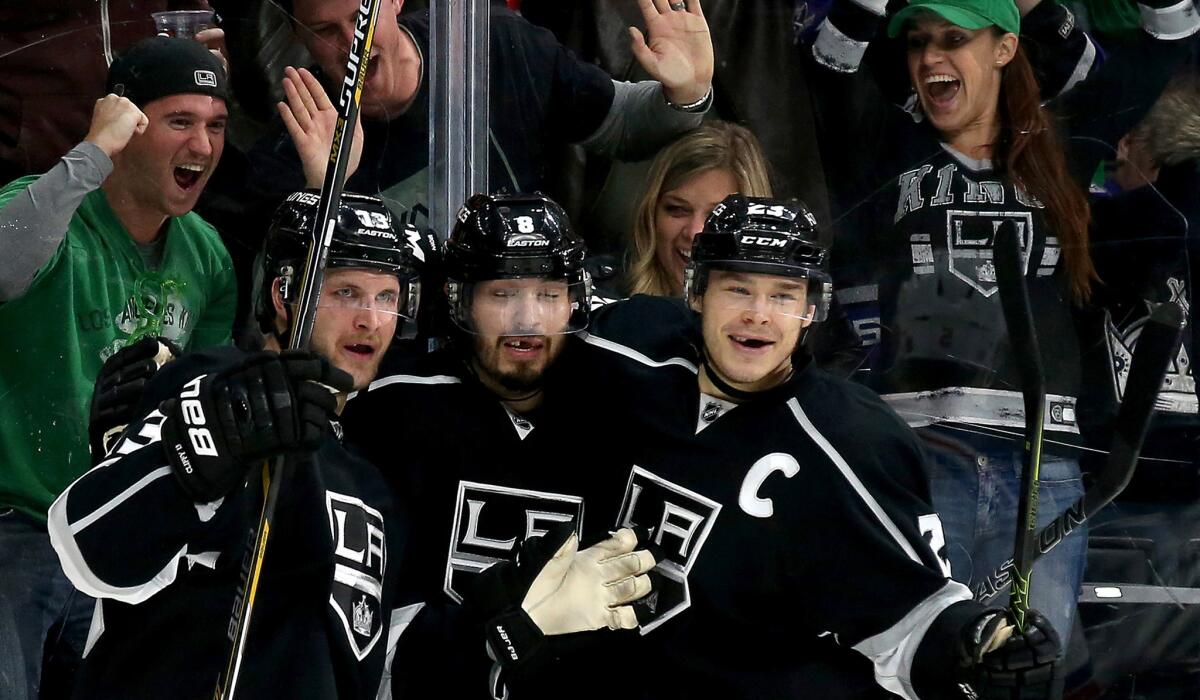 Kings captain Dustin Brown celebrates with teammates Kyle Clifford, left, and Drew Doughty, center, after a goal against the Rangers on March 17.