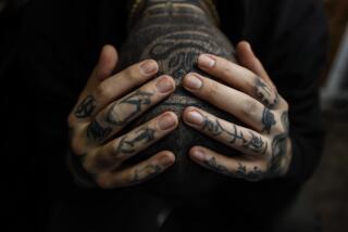 Venice, CA, Tuesday, November 21, 2023 - Ocean Front Tattoo artist Mikey Ekimoto wears Korean symbols on his ring finger that translate to "every moment is precious." On his pinkie finger, it reads "work hard and sacrifice one's self." a (Robert Gauthier/Los Angeles Times)