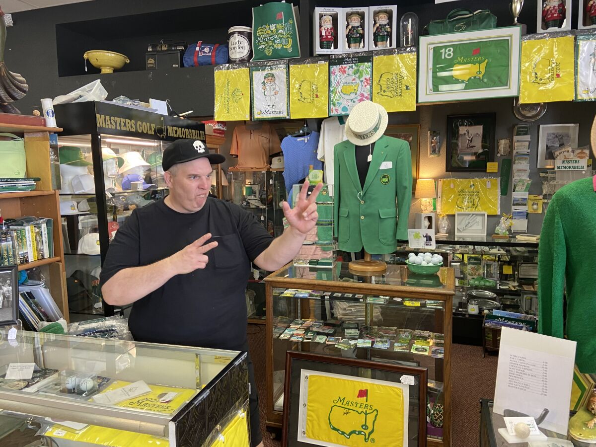 A man stands in a store jammed with memorabilia from the Masters golf tournament