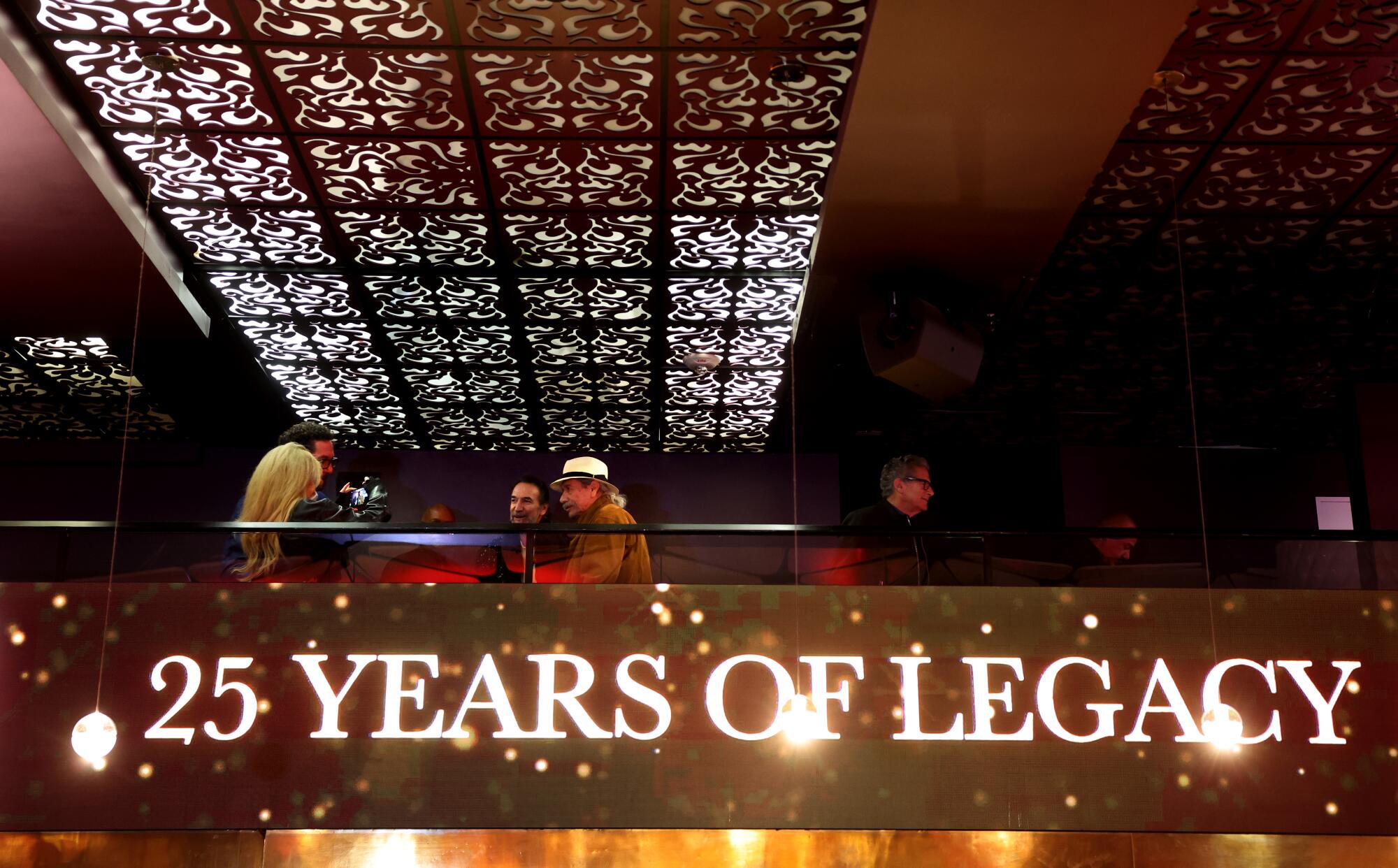 L'acteur Edward James Olmos est assis à une table au-dessus des mots "25 ans d'héritage."