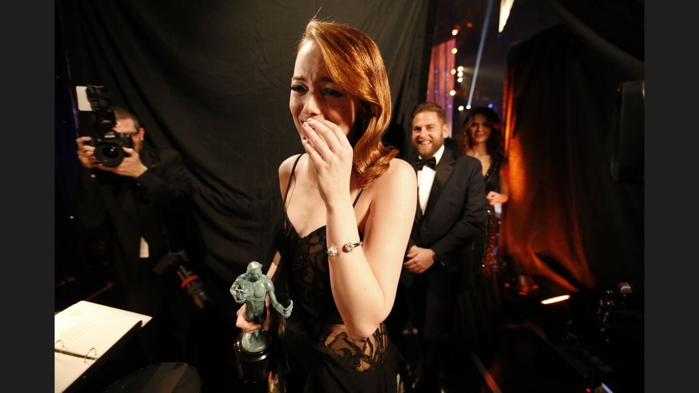 Emma Stone, followed by Jonah Hill, reacts backstage after winning Outstanding Performance by an Actress in a Leading Role for "La La Land."
