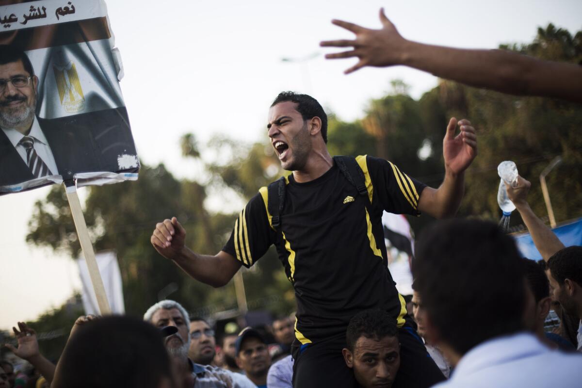 Supporters of Egypt's ousted President Mohamed Morsi chant slogans supporting the former leader during a protest near Cairo University in Giza, Egypt, on Sunday.