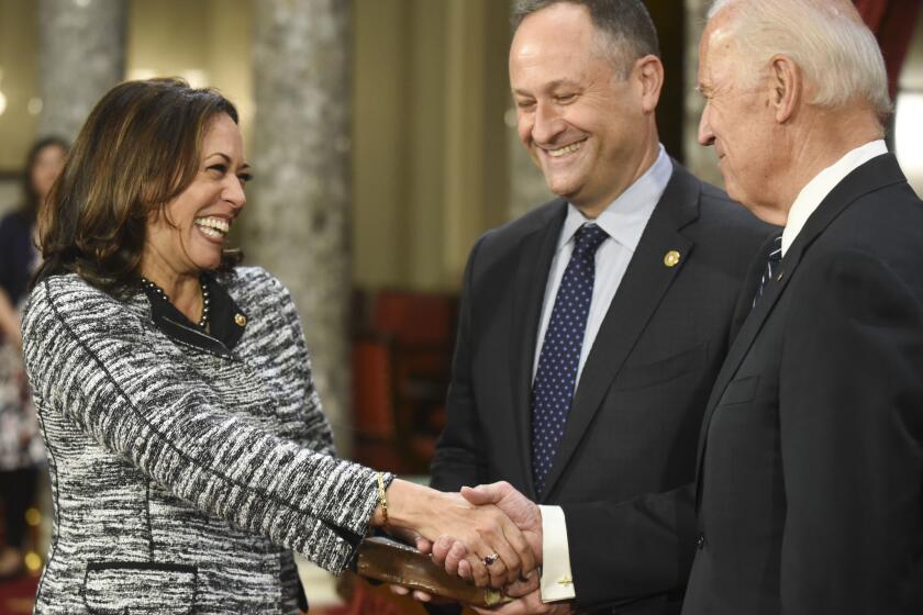 Vice President Joe Biden, right, shakes hands with Sen. Kamala Harris, D-Calif., as her husband Douglas Emhoff, looks on during a a mock swearing in ceremony in the Old Senate Chamber on Capitol Hill in Washington, Tuesday, Jan. 3, 2017, as the 115th Congress begins. (AP Photo/Kevin Wolf)