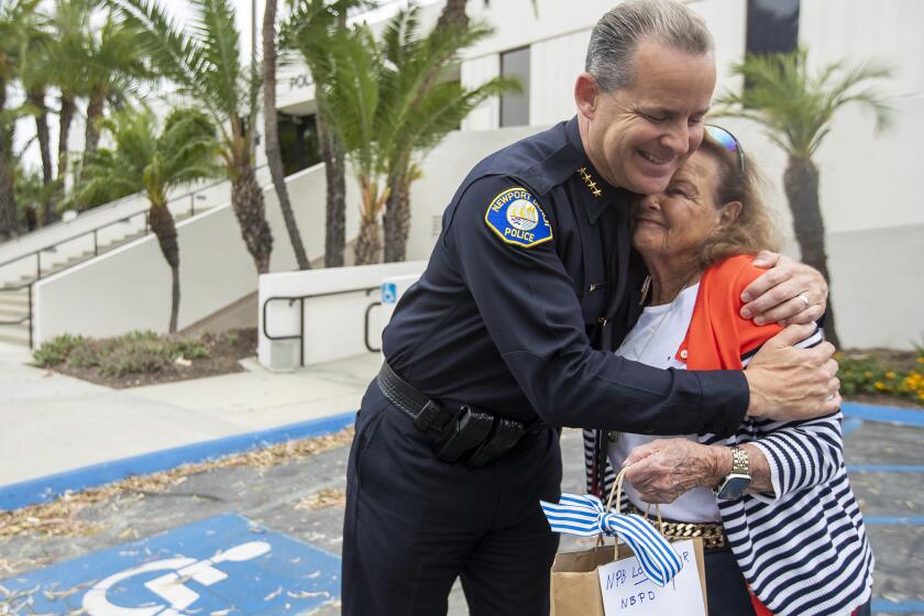 Dotty McDonald, 91, gets a hug from Newport Beach Police Department Chief Jon Lewis, after presenting him with $6000 worth of gift cards for the police department to use at Sgt. Pepperoni's.