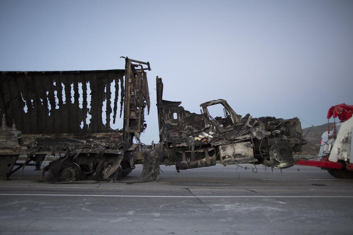 The scorched remains of a truck are towed at the North Fire, which caused people to abandon their vehicles and flee as flames jumped the 215 freeway on July 17, near Victorville, California. The fire has burned across 3,500 acres and a private drone was reported to have raised serious safety concerns for aircraft pilots fighting the fire.
