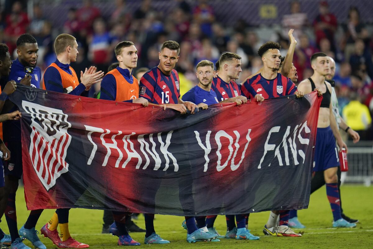 United States players hold a banner at the end of a FIFA World Cup qualifying match against Panama 