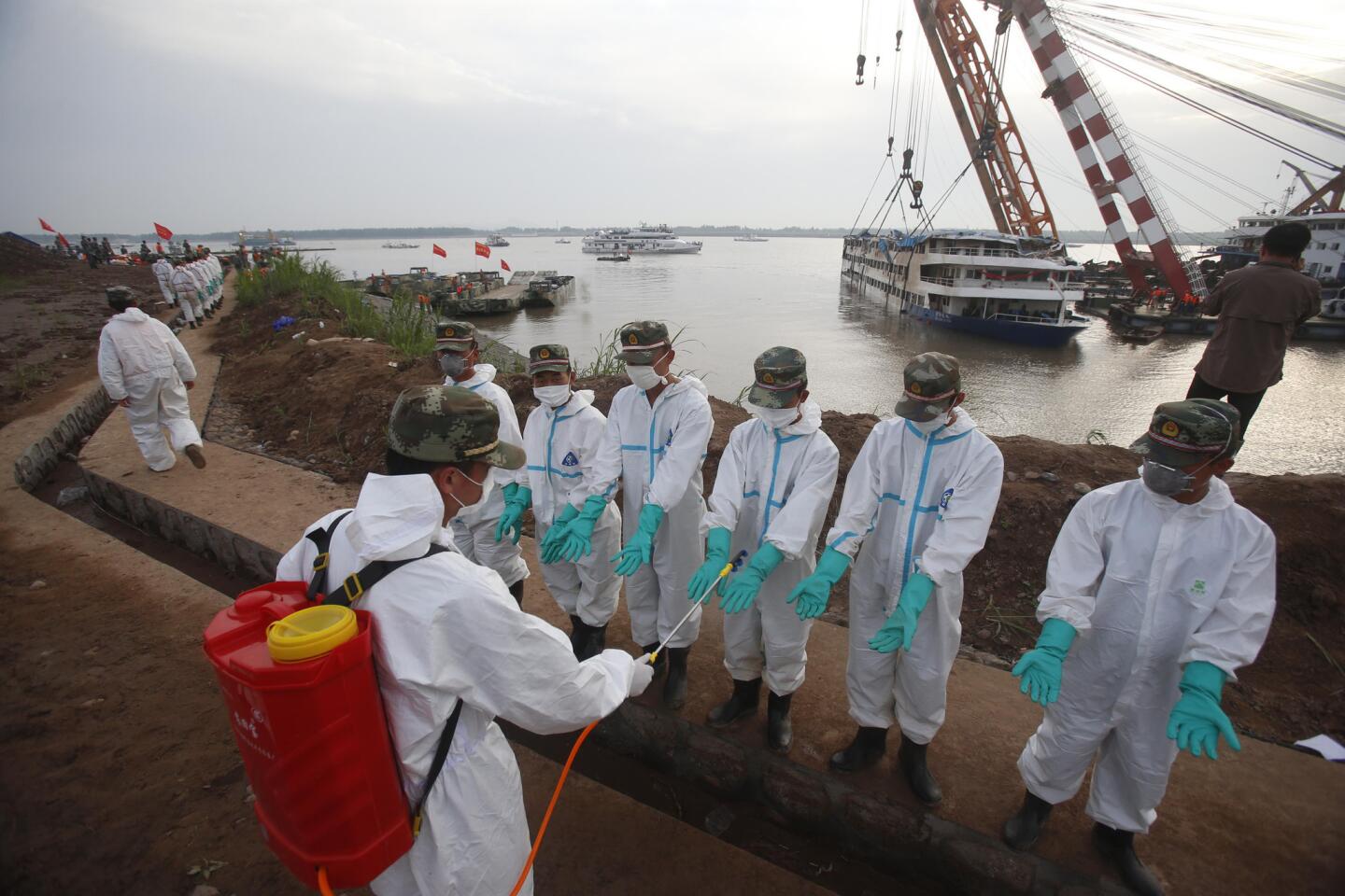 Rescuers are decontaminated at the site of the Eastern Star recovery operation in Jianli, China.