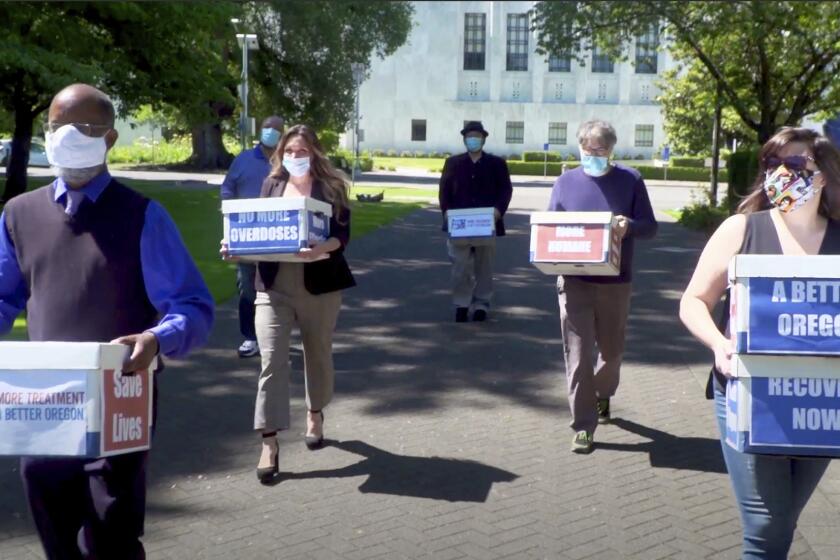 FILE - In this June 26, 2020, file photo taken from video, provided by the Yes on Measure 110 Campaign, volunteers deliver boxes containing signed petitions in favor of the measure to the Oregon Secretary of State's office in Salem, Ore. The measure said the U.S., possession of small amounts of heroin, cocaine, LSD and other hard drugs would be decriminalized in Oregon. Police in Oregon can no longer arrest someone for possession of small amounts of heroin, methamphetamine and other hard drugs as the ballot measure that decriminalized them took effect on Monday, Feb. 1, 2021. (Yes on Measure 110 Campaign via AP, File)