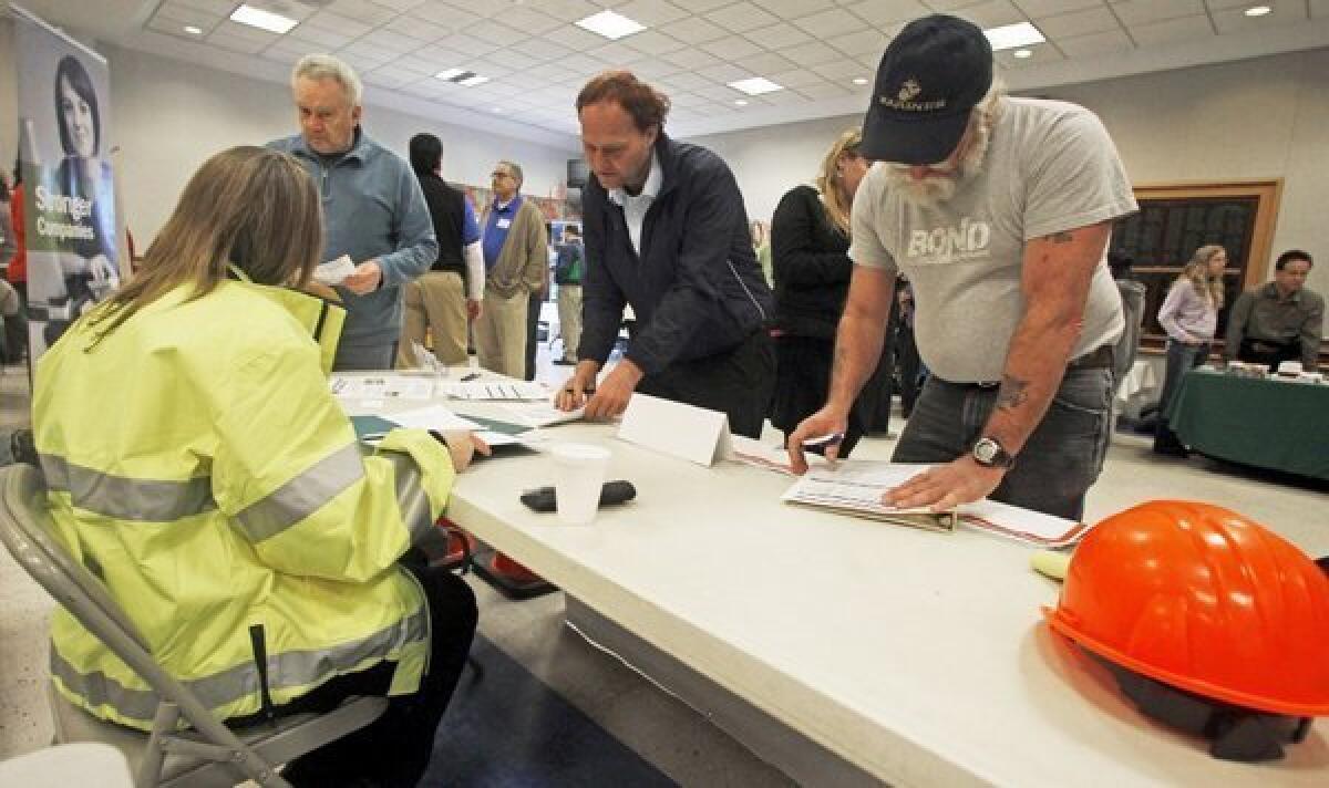 People fill out applications at a job fair in Montpelier, Vt.