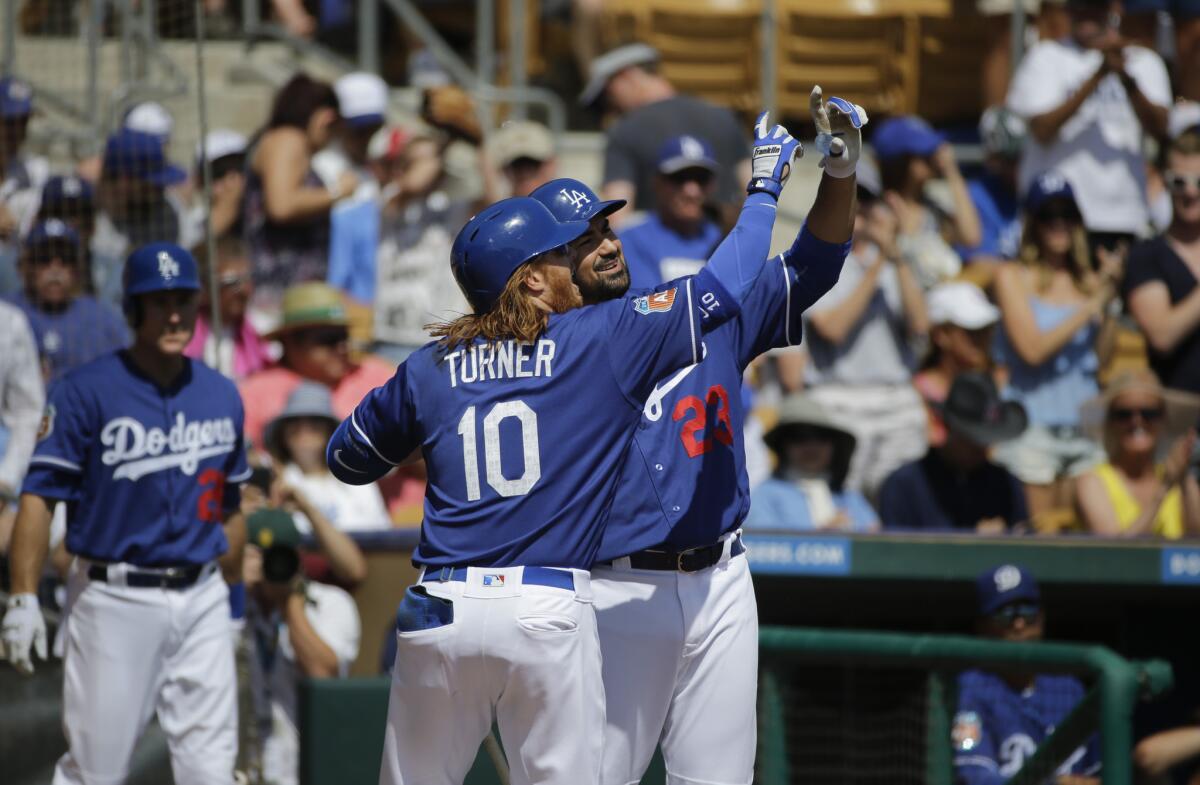 Justin Turner, center, celebrates his home run with Adrian Gonzalez during the first inning of the Dodgers' exhibition game against the Seattle Mariners on Monday.