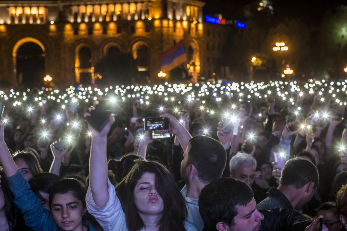 People hold their cellphone flashlights overhead during a gathering in Republic Square to hear protest leader Nikol Pashinian address the crowd on the eve of his election as prime minister.