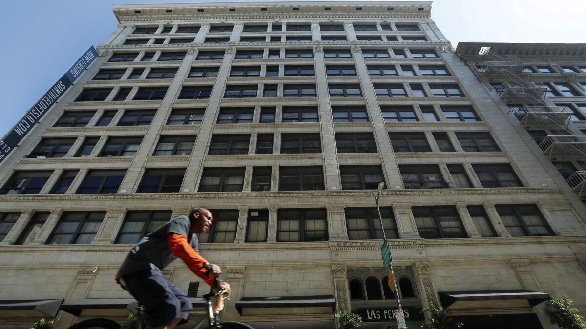 A bicyclist pedals along 6th Street in downtown Los Angeles, past the Santa Fe Lofts building. Completed in 1908 as offices, it had been converted to apartments and was just sold for nearly $70 million to a Sherman Oaks firm.