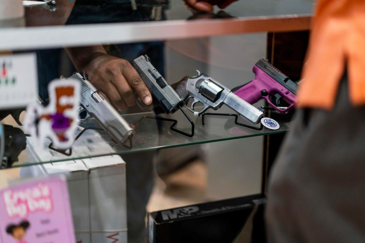 A customer views a handgun for sale at Redstone Firearms in Burbank in 2022.