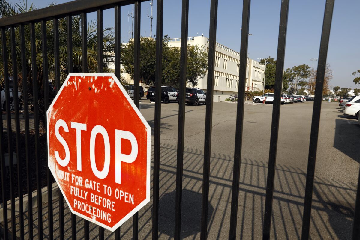 A building and a parking lot behind a gate