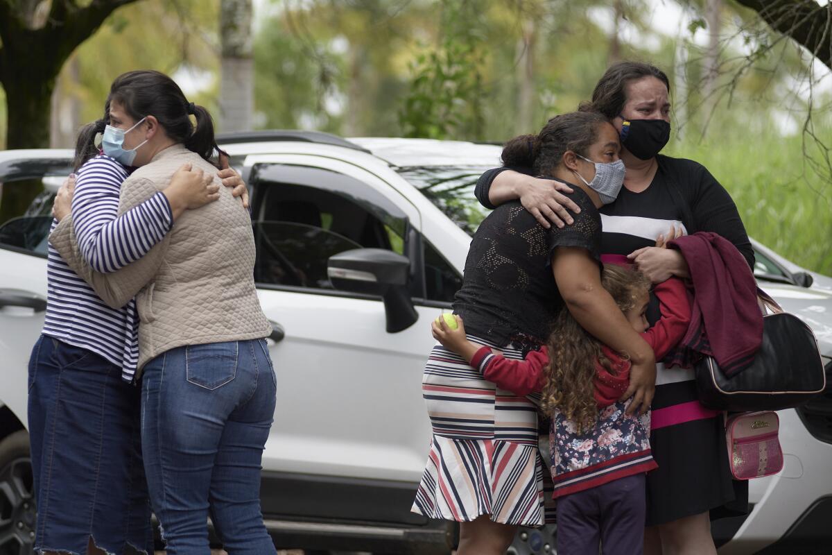 People embrace as they wait for information about missing relatives.