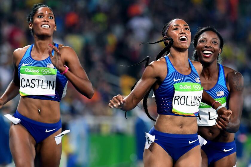 American hurdlers (from left) Kristi Castlin, Brianna Rollis and Nia Ali check the scoreboard to see that they swept the women's 100-meter hurdles.