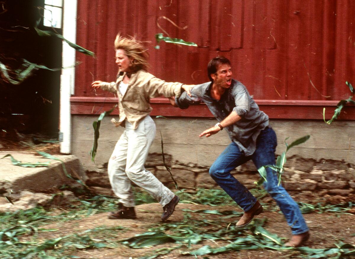 Two people run from a violent storm.