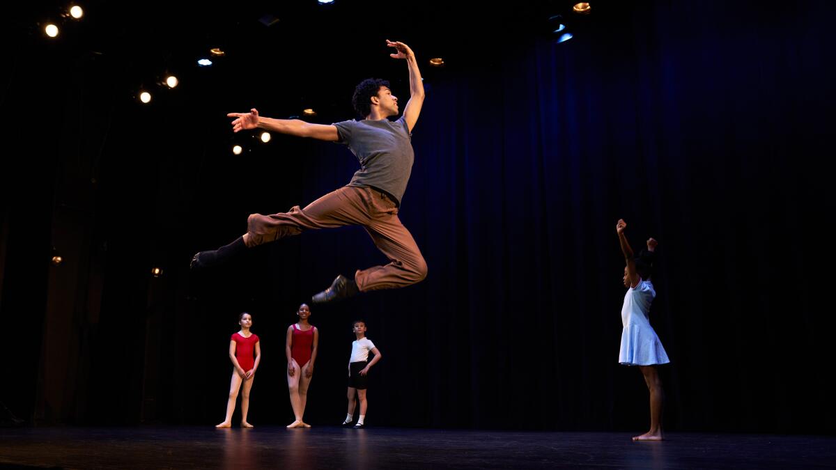 A dancer leaps on stage.