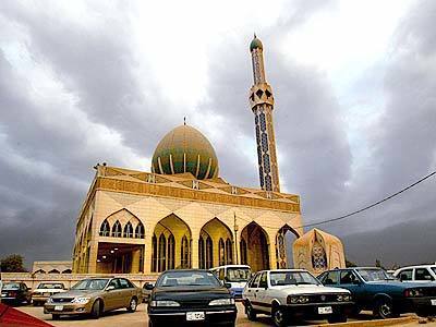 Smoke and cumulus clouds mingle in the sky over Al Buniya Mosque in central Baghdad.