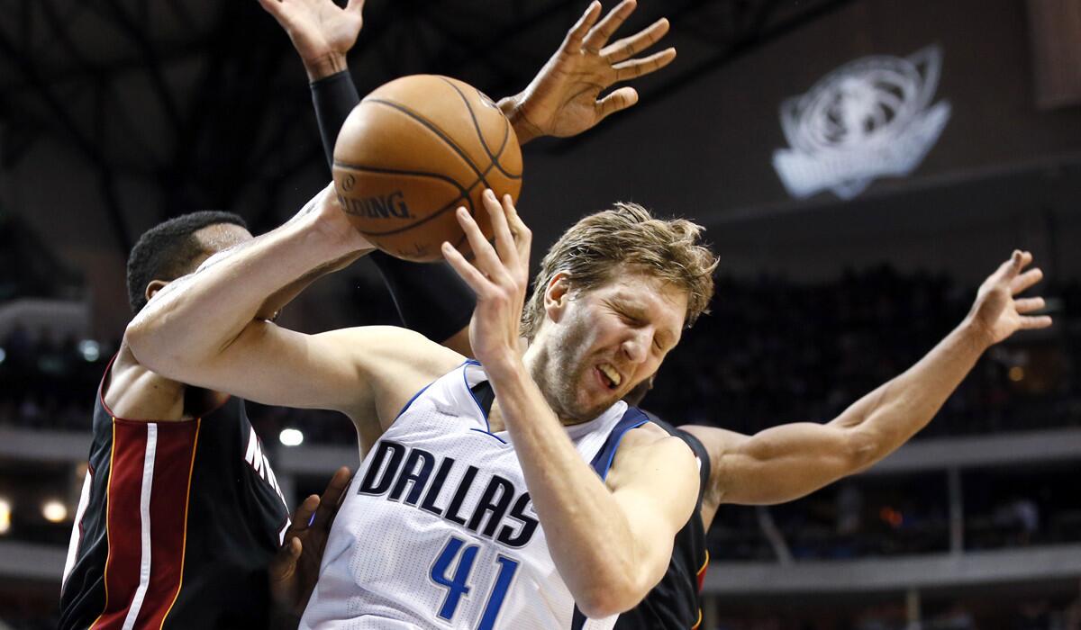 Mavericks power forward Dirk Nowitzki (41) is fouled going to the basket by Heat forward Shawne Williams, left, in the second half Sunday.