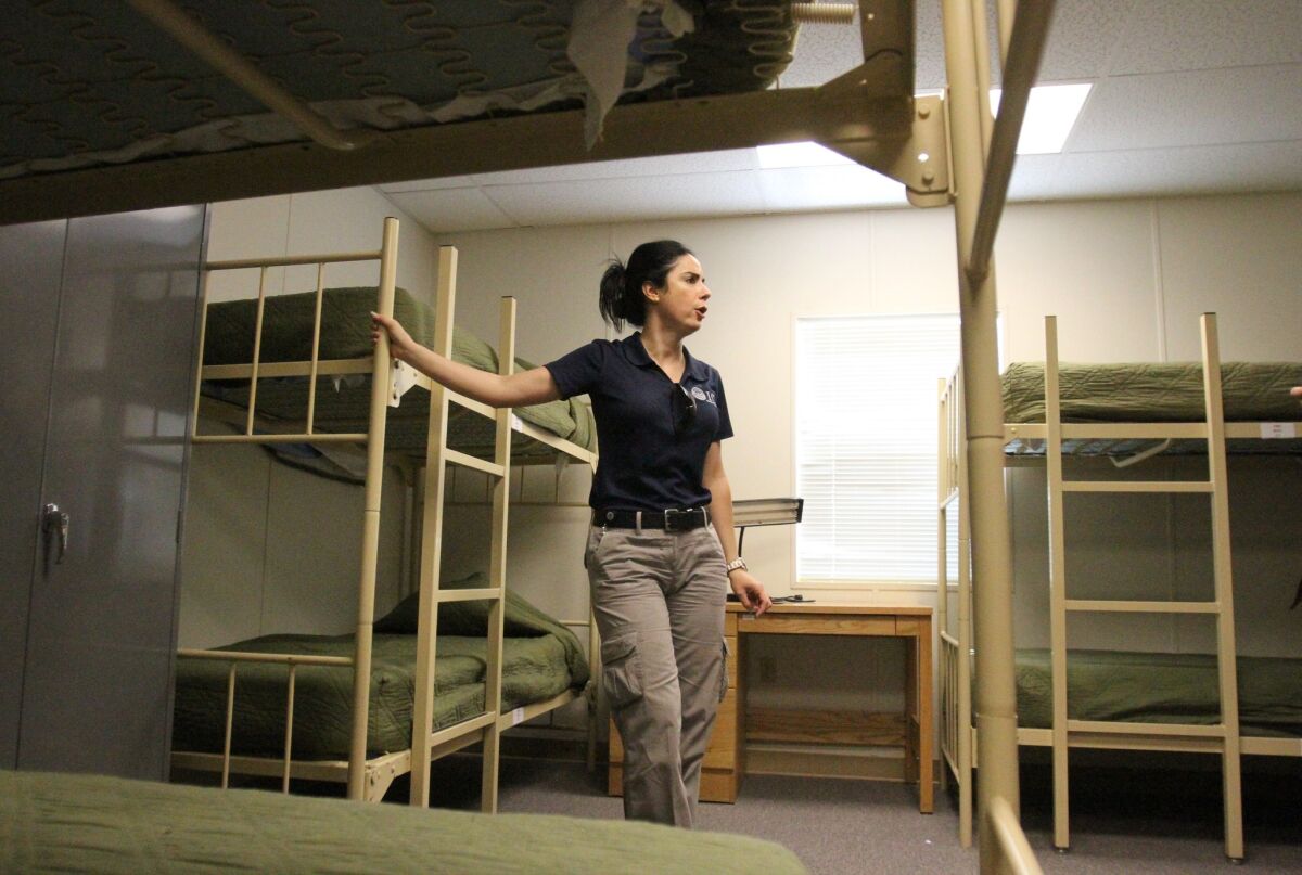 Barbara Gonzalez, public information officer for Immigration and Customs Enforcement, shows a dormitory where immigrant families are housed at the Artesia Residential Detention Facility in New Mexico.