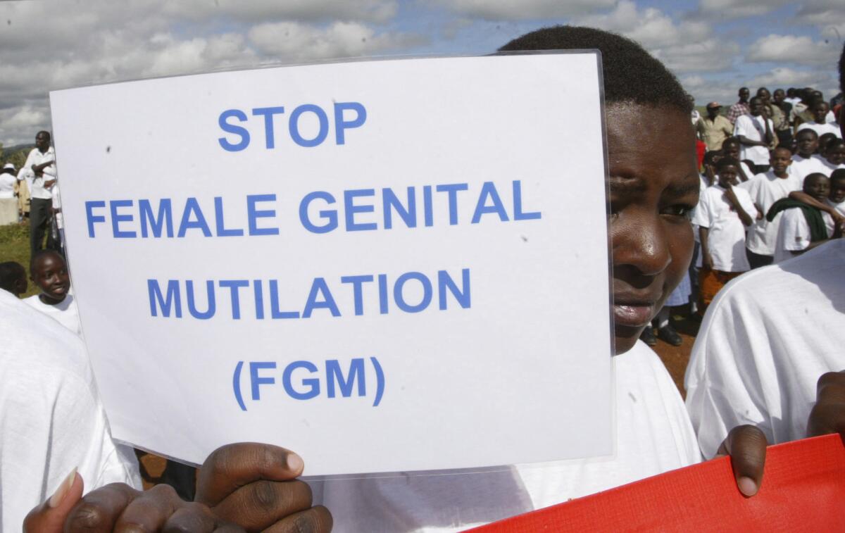 A Masai girl holds a sign reading "Stop female genital mutilation" during an event in Kilgoris, Kenya.