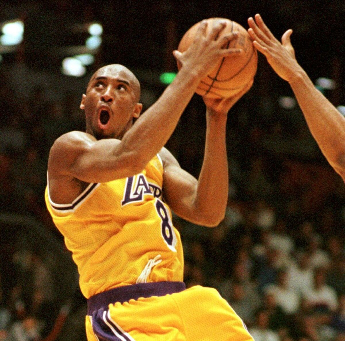 Lakers' Kobe Bryant is airborne as he holds the ball.