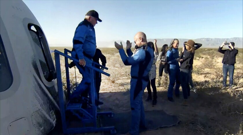 William Shatner est accueilli par Jeff Bezos alors qu'il débarque de la capsule Blue Origin.