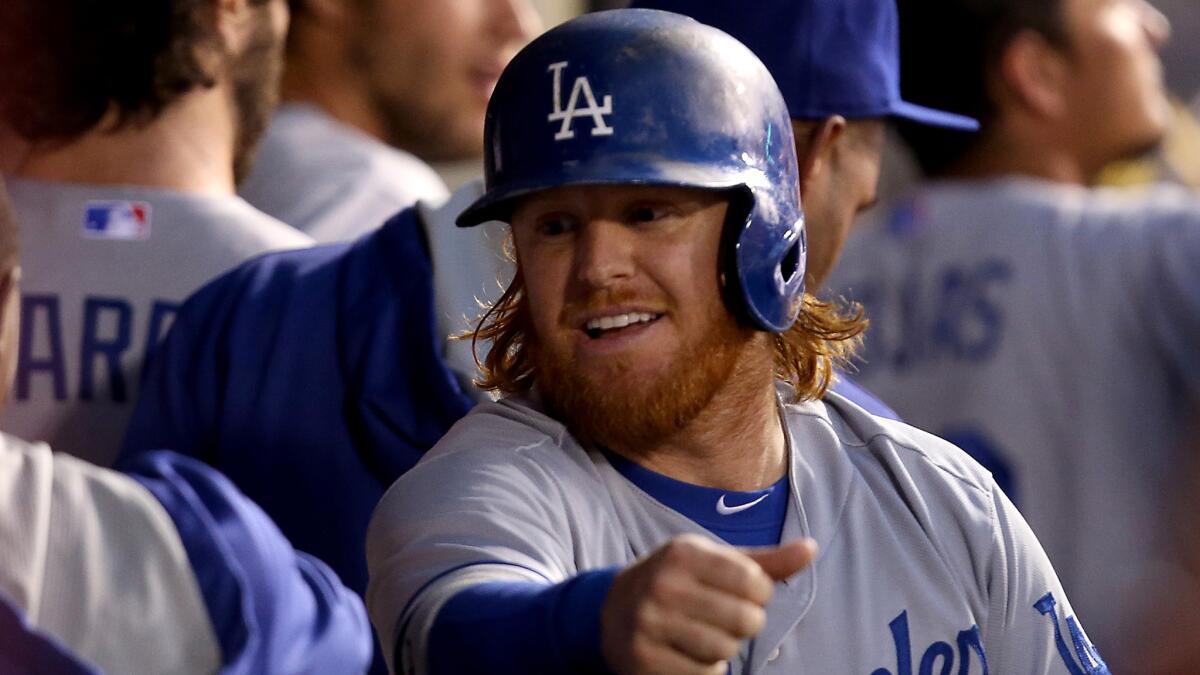 Dodgers infielder Justin Turner celebrates in dugout after scoring a run against the Angels on Aug. 7. Turner has taken over a valuable utility role for the Dodgers this season.