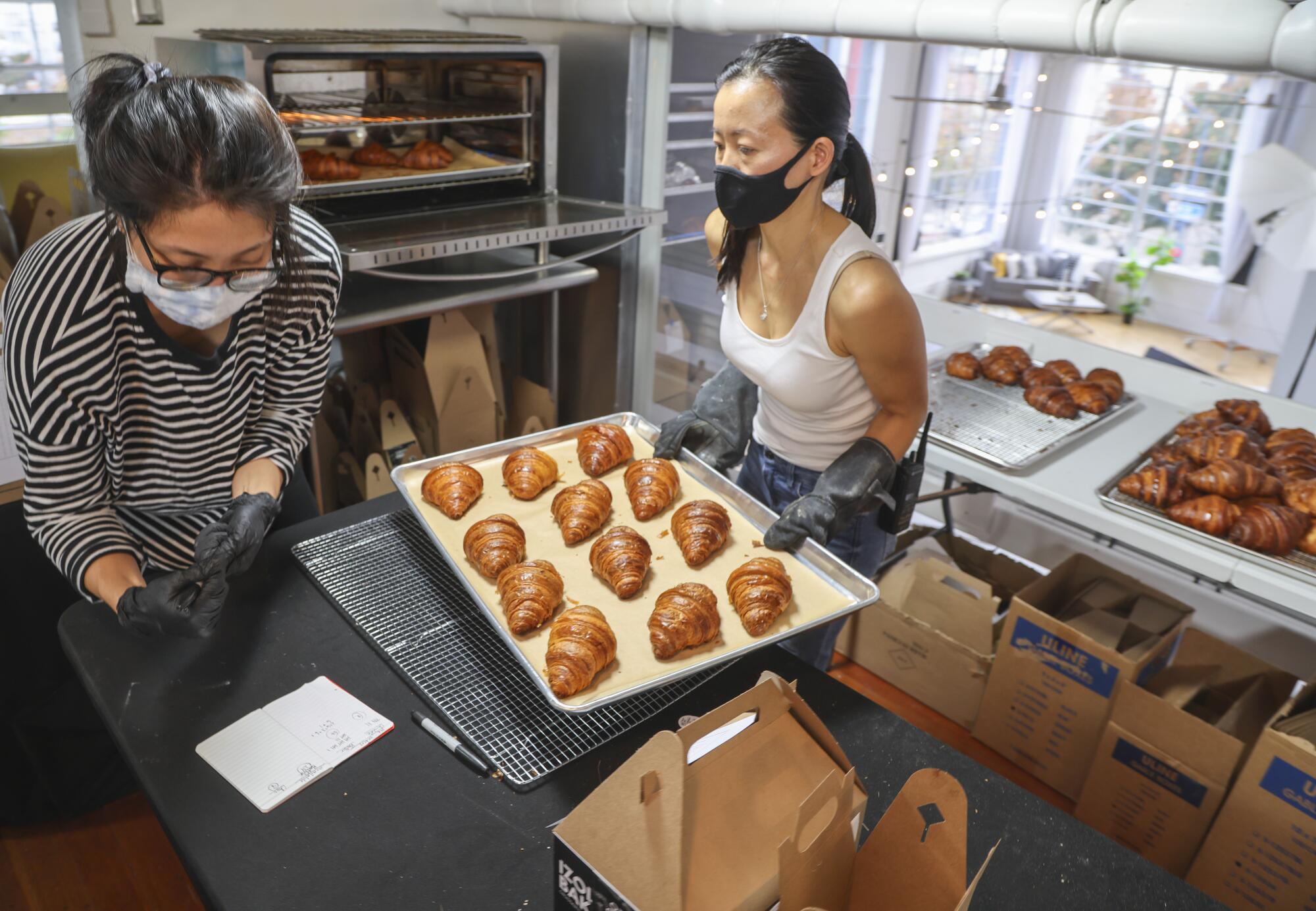 Baker Jennifer Chen, right, and Jasmine Liu prepare baked goods.