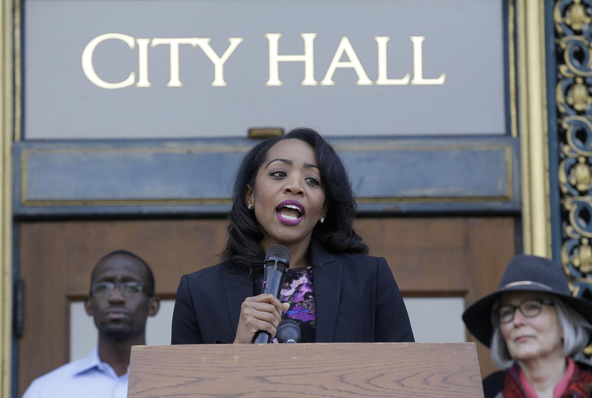 A woman speaks into a microphone at a lectern