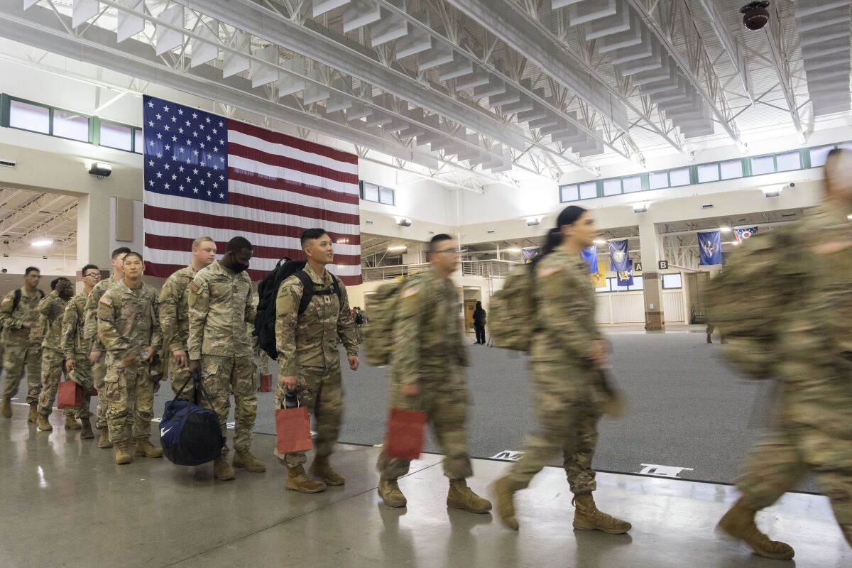 About 130 soldiers with the U.S. Army's 87th Division Sustainment Support Battalion, 3rd Division Sustainment Brigade, wait to board a chartered plane during their deployment to Europe, Friday, March 11, 2022, at Hunter Army Airfield in Savannah, Ga. The unit is attached to the Army's 3rd Infantry Division out of Fort Stewart, Ga., and will join the 3,800 troops already deployed in support of NATO in Eastern Europe. (AP Photo/Stephen B. Morton)